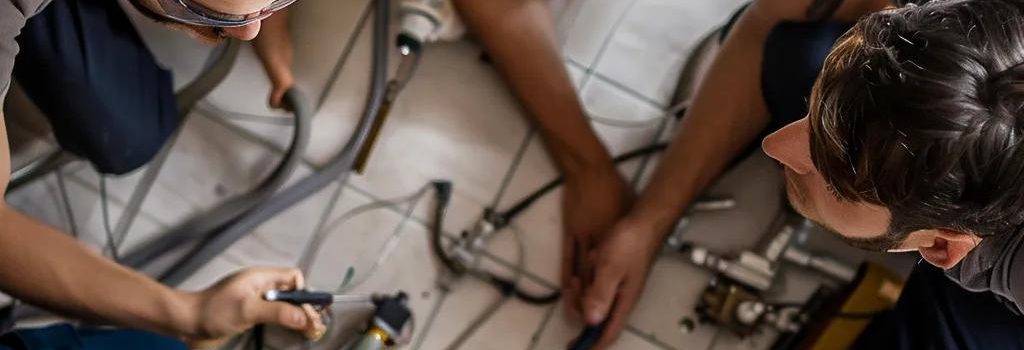 Plumbers collaborating on emergency plumbing services, emphasizing teamwork and efficiency